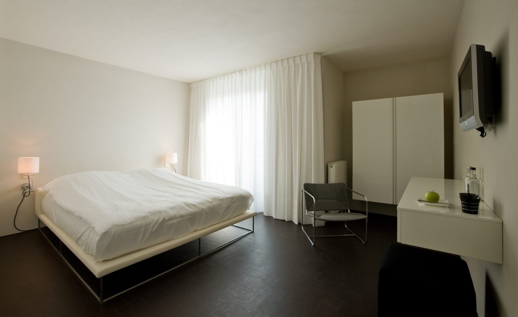 Hotelkamer van hotel Elzenduin met zwevend bedframe, donkere vloer en maatwerk-inbouwkast